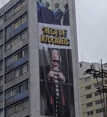 ZEMA ESTENDE PAINEL NA AVENIDA PAULISTA COM BONECO DE MORAES ATRÁS DAS GRADES