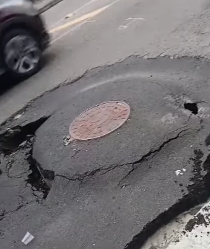 ASFALTO CEDE E ABRE BURACO APÓS OBRA DA SABESP NA RUA DOS VIANAS; MORADORA RECLAMA DA FALTA DE SINALIZAÇÃO